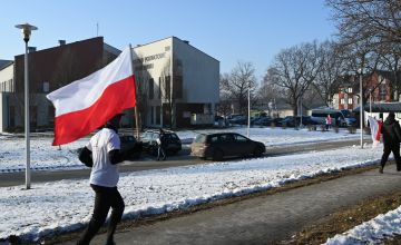 Uczestnik biegu z flagą na tle budynku starostwa